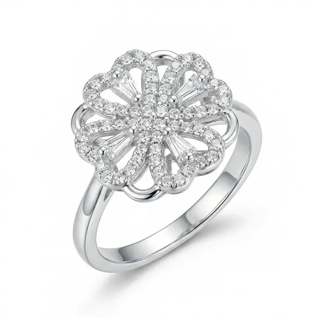 Silver ring with a floral design and clear stones on a white background
