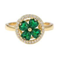 Gold ring with green gemstone and diamond accents on a white background