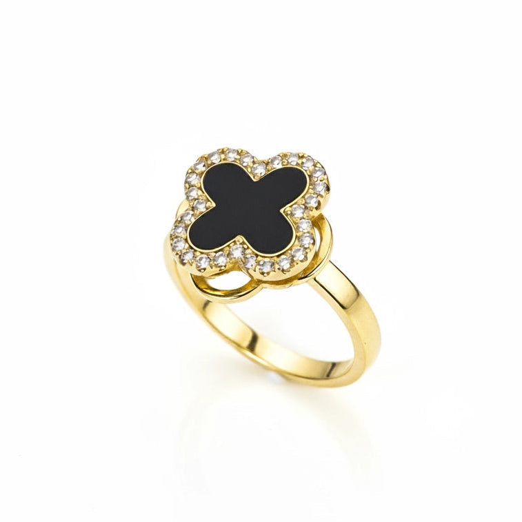 Gold ring with a black clover-shaped center on a white background