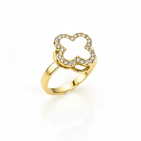 Gold ring with a clover-shaped design on a white background