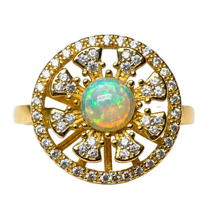 Gold ring with opal center stone and diamond accents on a white background