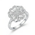 Silver ring with a floral design and clear stones on a white background