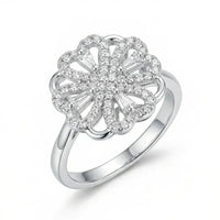 Silver ring with a floral design and clear stones on a white background